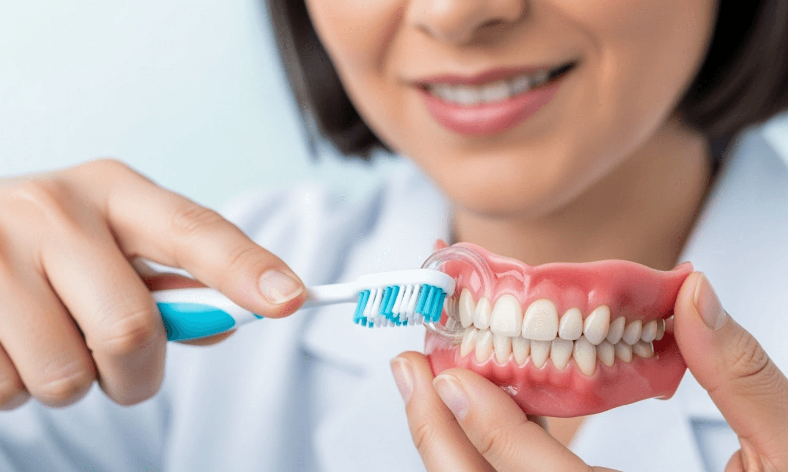 Image of a person demonstrating proper brushing technique on teeth with veneers - Composite Veneers